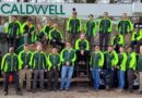 Caldwell Tree Care employees in front of a bucket truck.