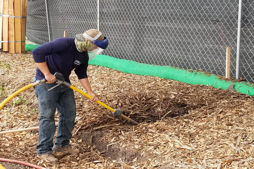 Tree care experts with Texas-based Arborilogical use an air excavator to loosen compact soil.  Source: Arborilogical