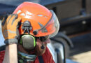 A tree care worker wearing a helmet, hearing protection and safety glasses preparing to operate a aerial lift.